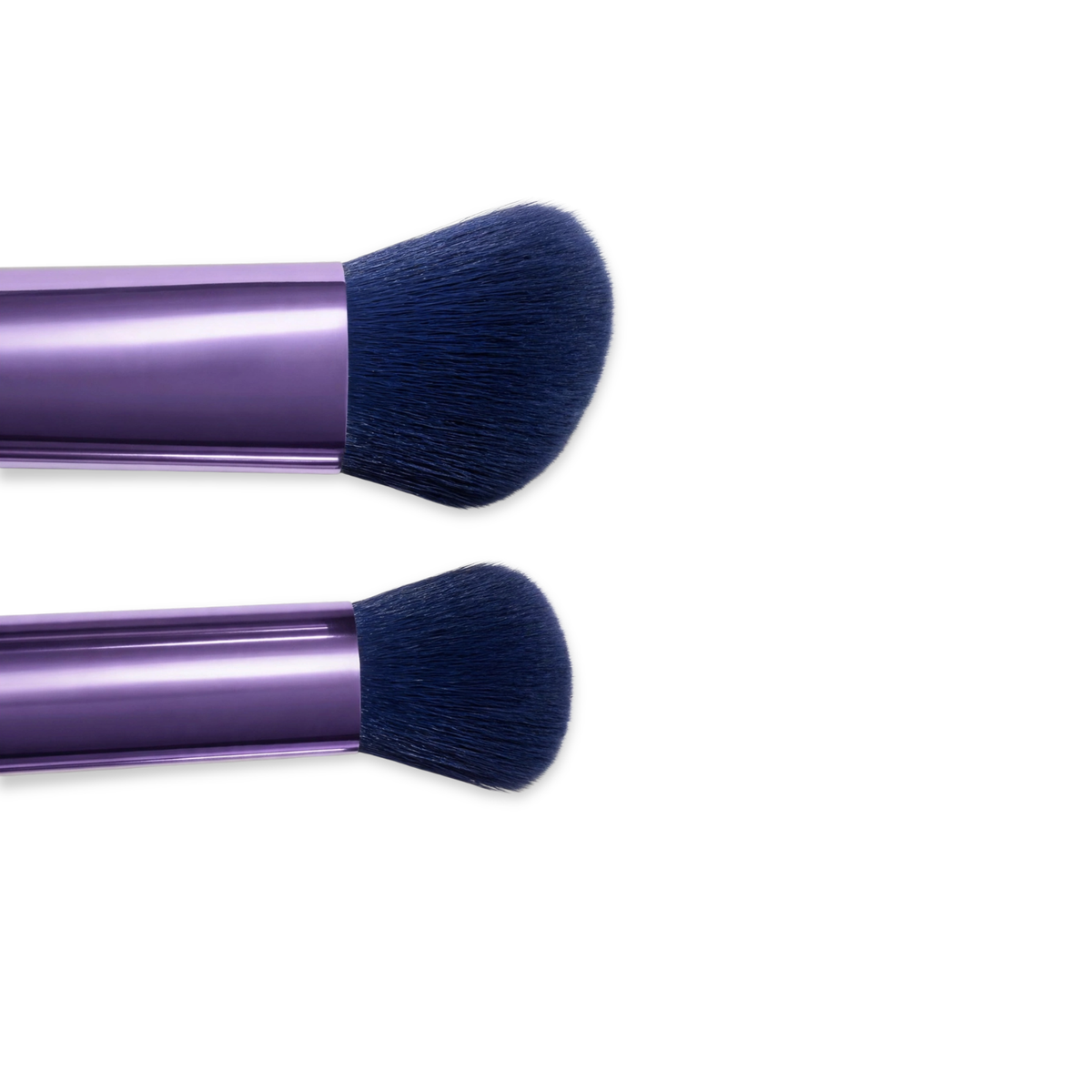 Two travel makeup brush heads side-by-side.
Close-up of two veraVia brush heads on purple metallic handles — a larger angled flat-top bristle head above a smaller rounded dome, both with dense navy blue synthetic fibres, on white background.