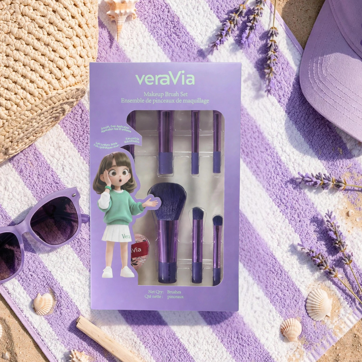 veraVia travel makeup brush set retail box displayed flat on a purple-striped beach towel, surrounded by purple sunglasses, a purple cap, seashells, lavender sprigs, and a woven basket — summer travel lifestyle