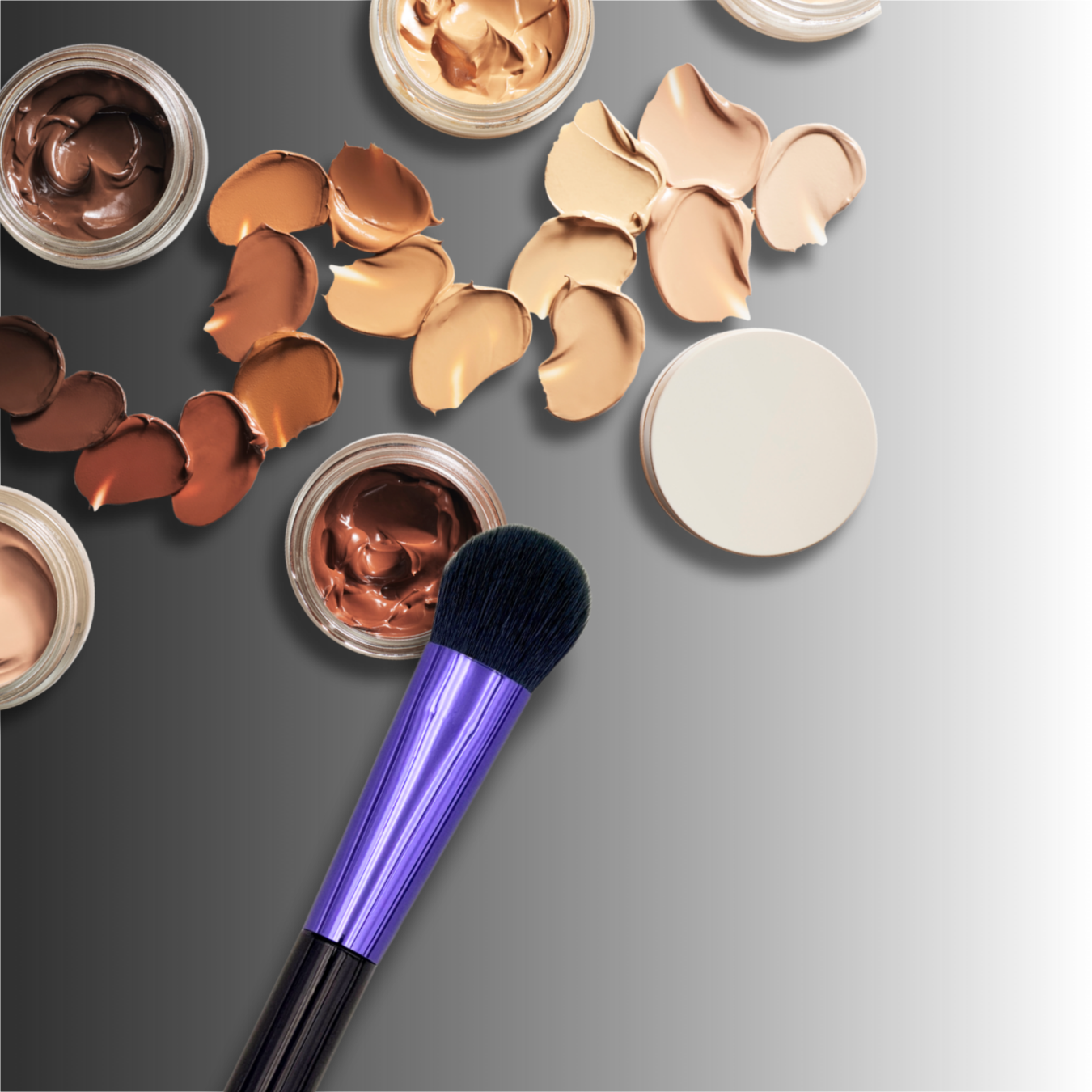 veraVia amethyst makeup brush angled over colorful cream concealer swatches