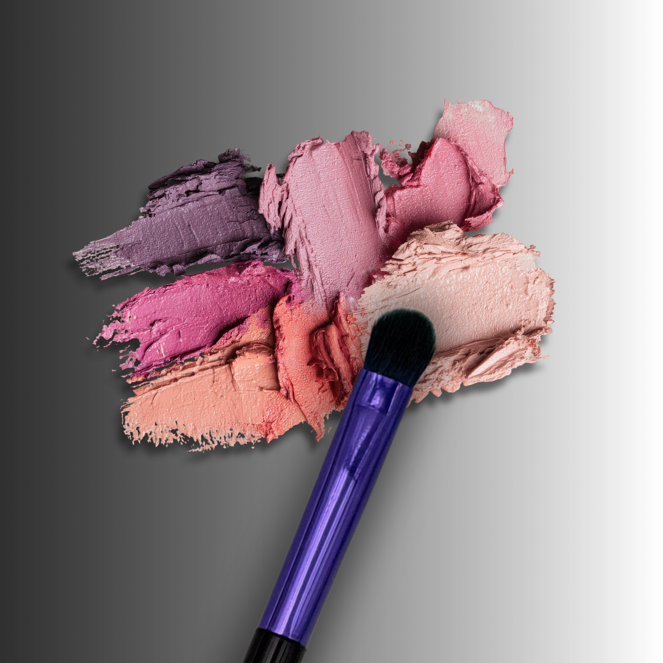 veraVia flame eyeshadow brush styled over textured pink and purple powder pigments
